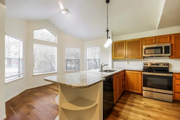 a kitchen with a stove a sink and a microwave