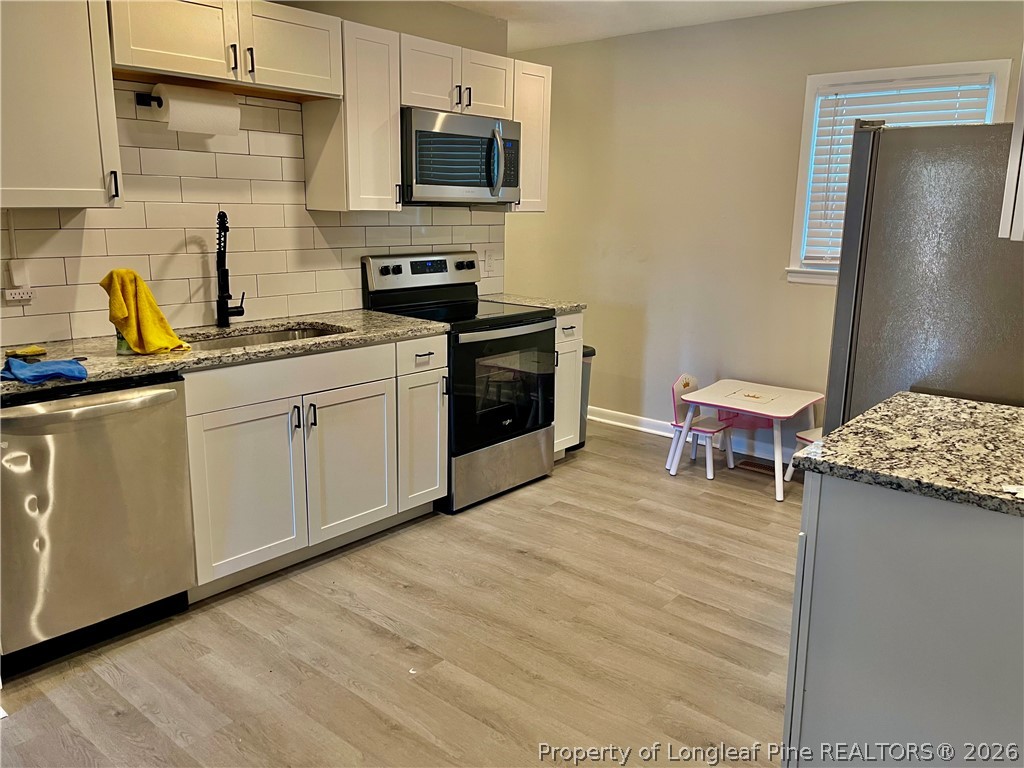 3610 Yorktown Road Hope Mills, NC 28348 - Photo 9 of 30 a kitchen with stainless steel appliances a stove top oven a sink a counter space and cabinets