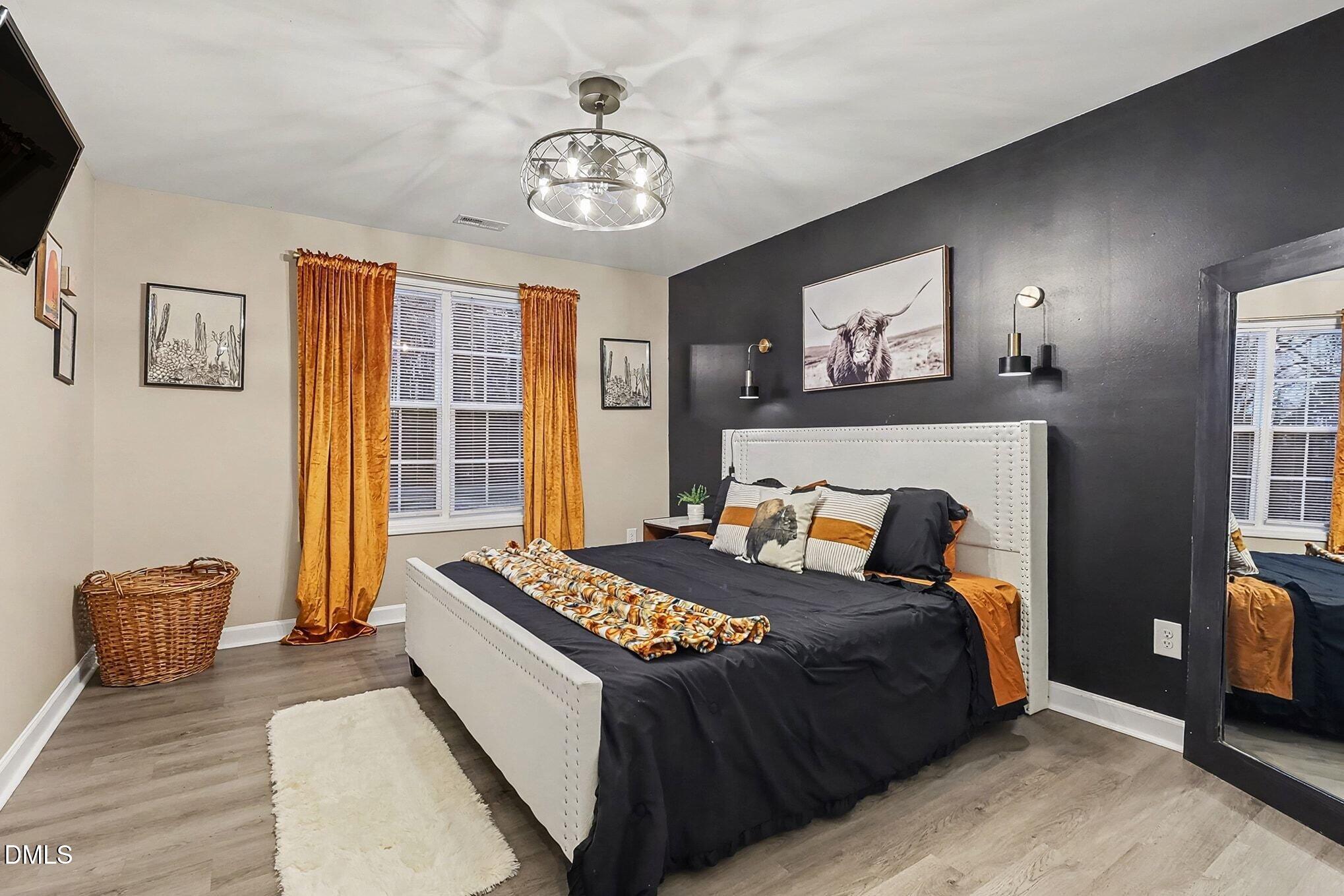 115 Southern High School Road Graham, NC 27253 - Photo 16 of 34 a bedroom with a bed and a chandelier