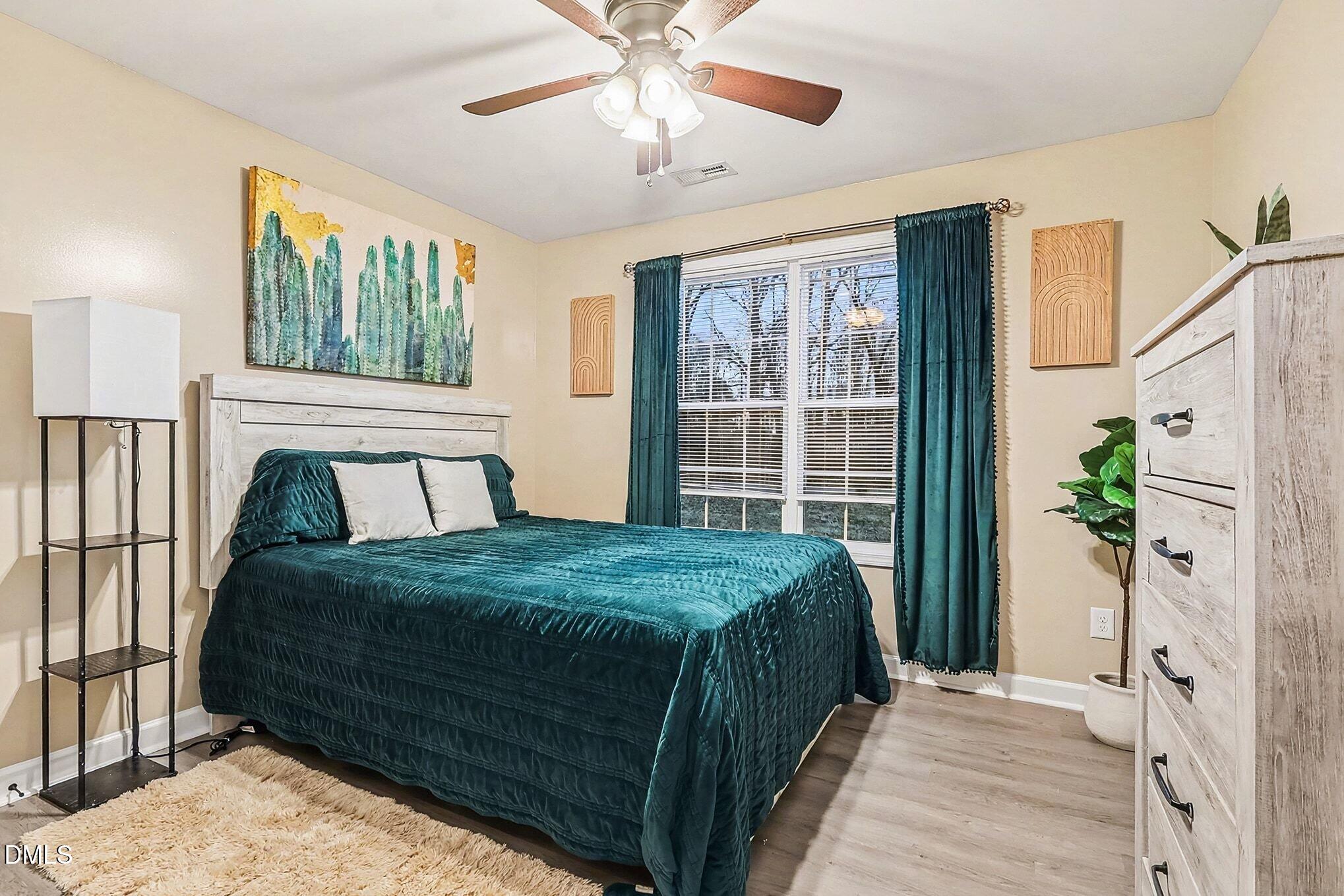 115 Southern High School Road Graham, NC 27253 - Photo 20 of 34 a bedroom with a large bed and a chandelier