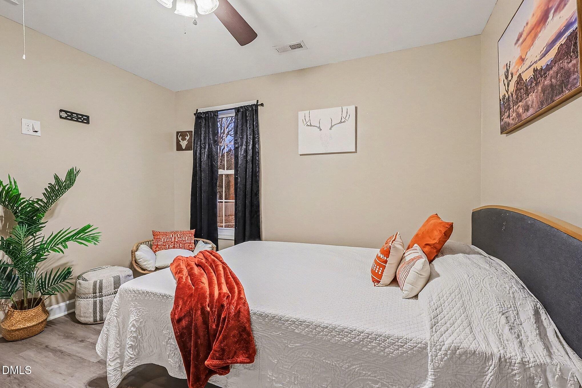 115 Southern High School Road Graham, NC 27253 - Photo 24 of 34 a bedroom with a bed and a potted plant