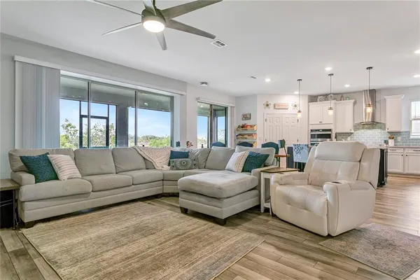 a kitchen with kitchen island granite countertop a table chairs stove a refrigerator and cabinets