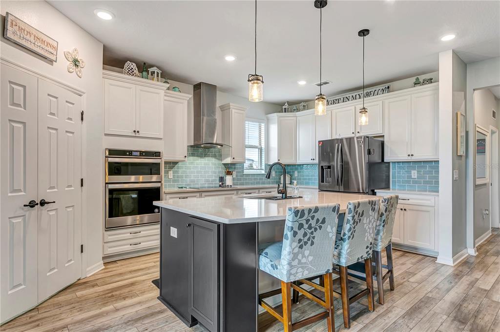 11701 Brighton Knoll Loop Riverview, FL 33579 - Photo 16 of 70 a large kitchen with granite countertop a table chairs stainless steel appliances and wooden floor