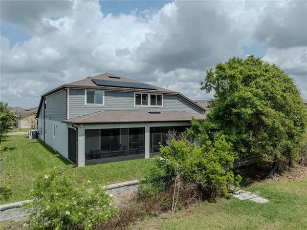 an aerial view of a house with a yard and large tree