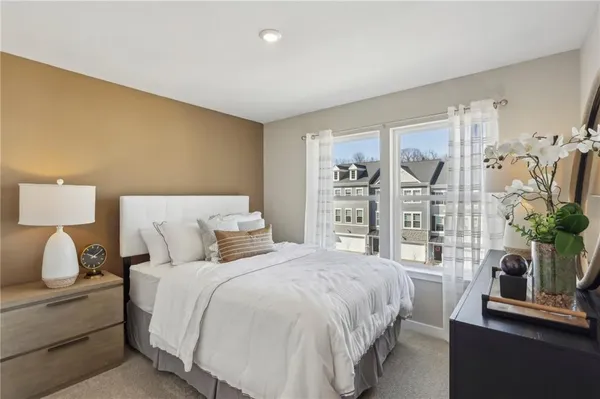 a bedroom with a bed and a potted plant