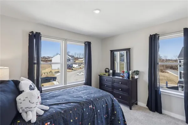 a bedroom with a bed and large windows
