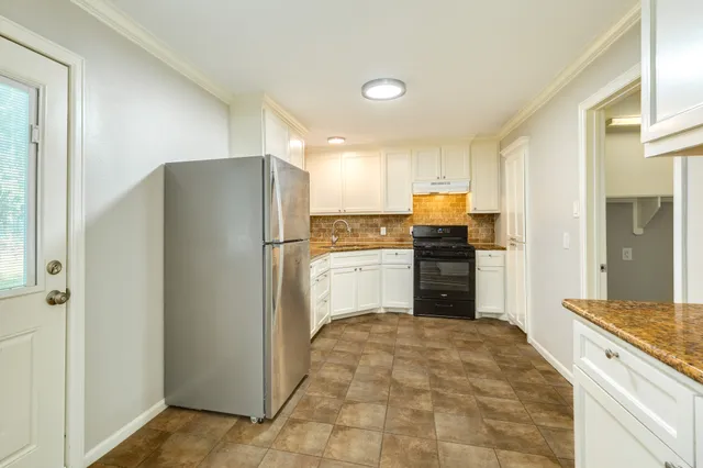 a kitchen with a refrigerator and a stove