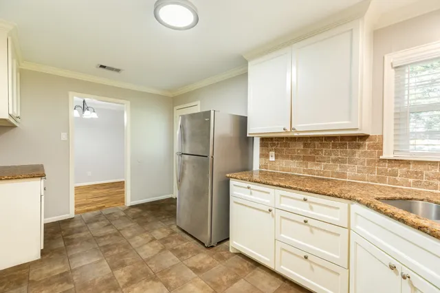 a kitchen with a refrigerator sink and cabinets