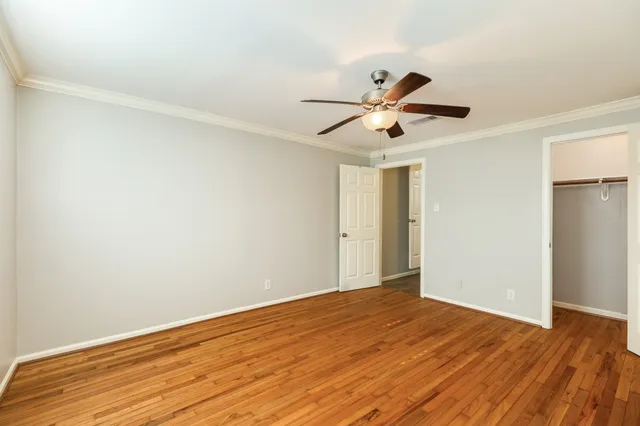 a view of a big room with wooden floor and a ceiling fan