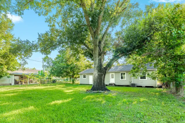 a front view of a house with a garden and trees