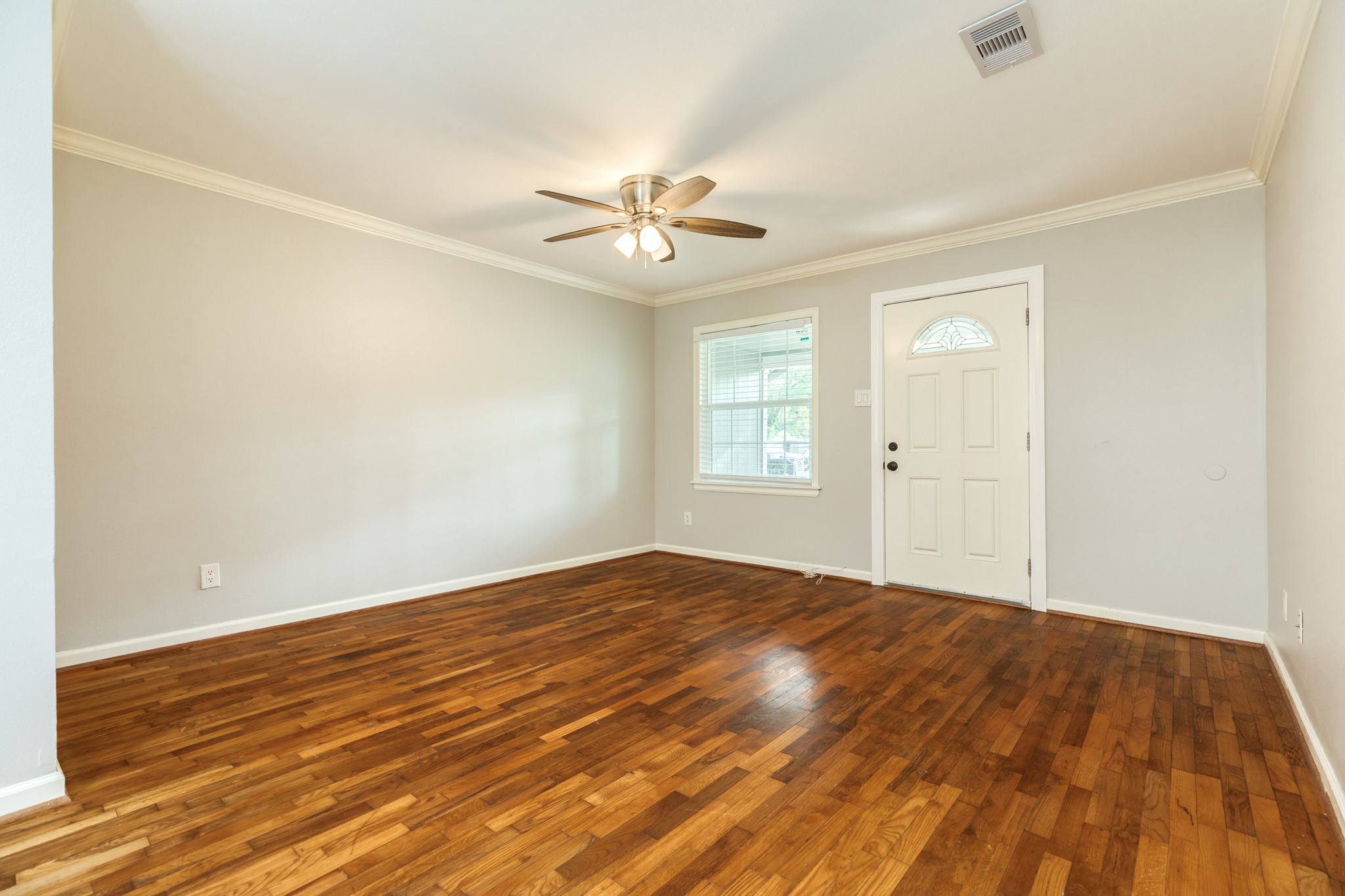 840 South Morgan Street Angleton, TX 77515 - Photo 7 of 28 an empty room with wooden floor ceiling fan and windows