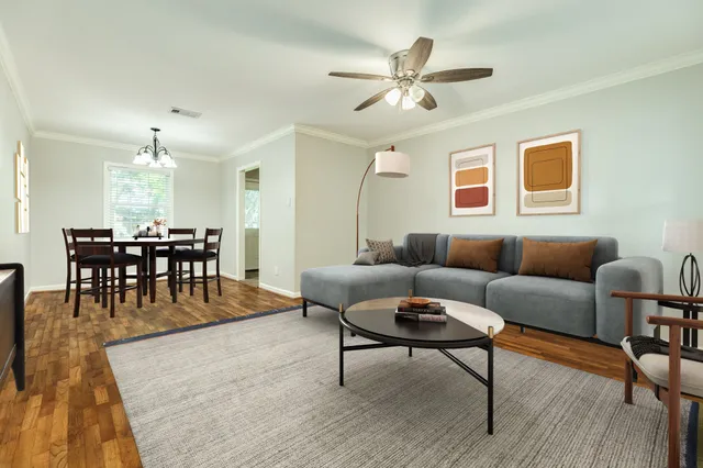 a living room with furniture a dining table and a chandelier