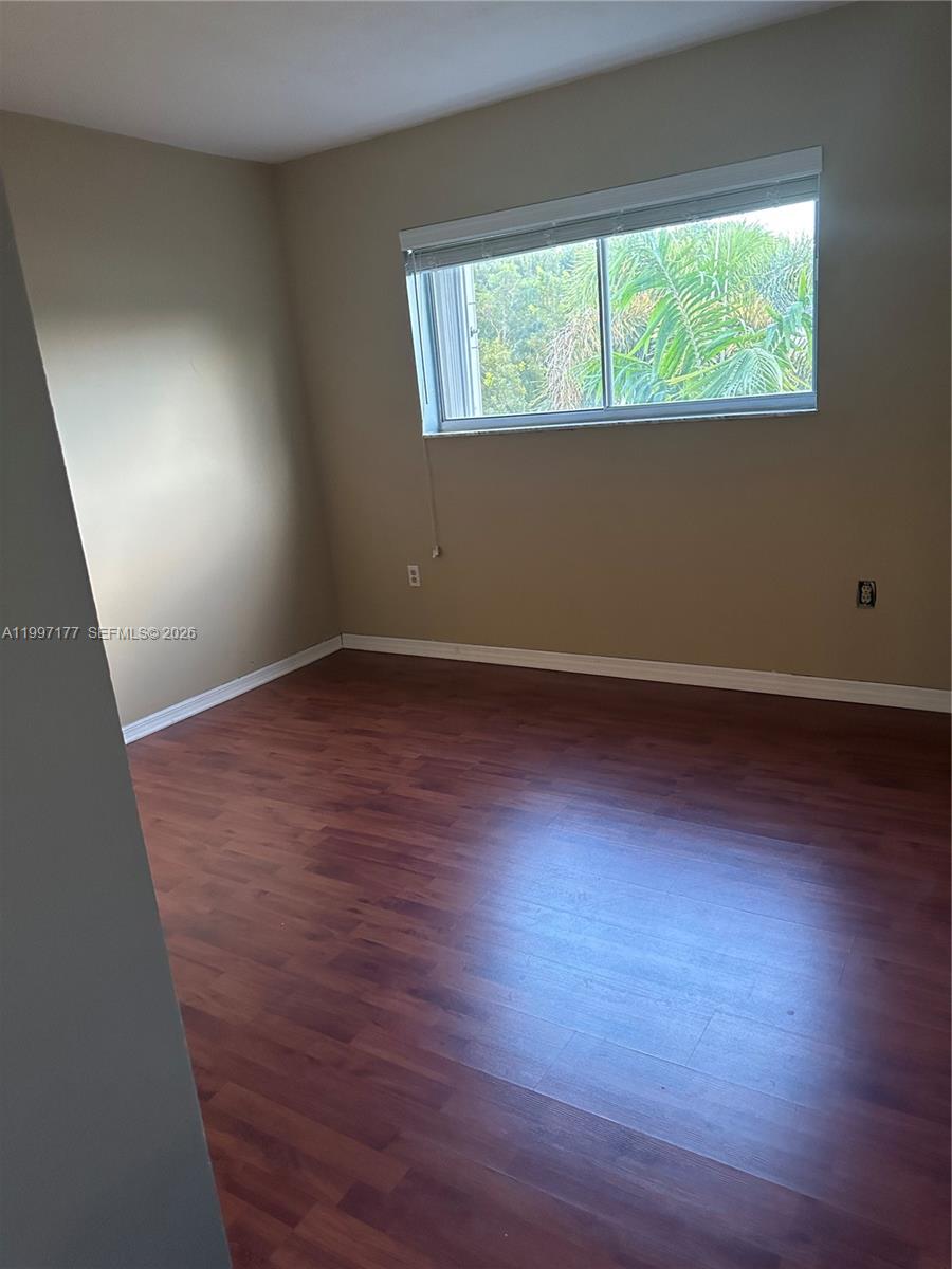 9724 Southwest 142nd Place Miami, FL 33186 - Photo 20 of 36 an empty room with wooden floor and windows