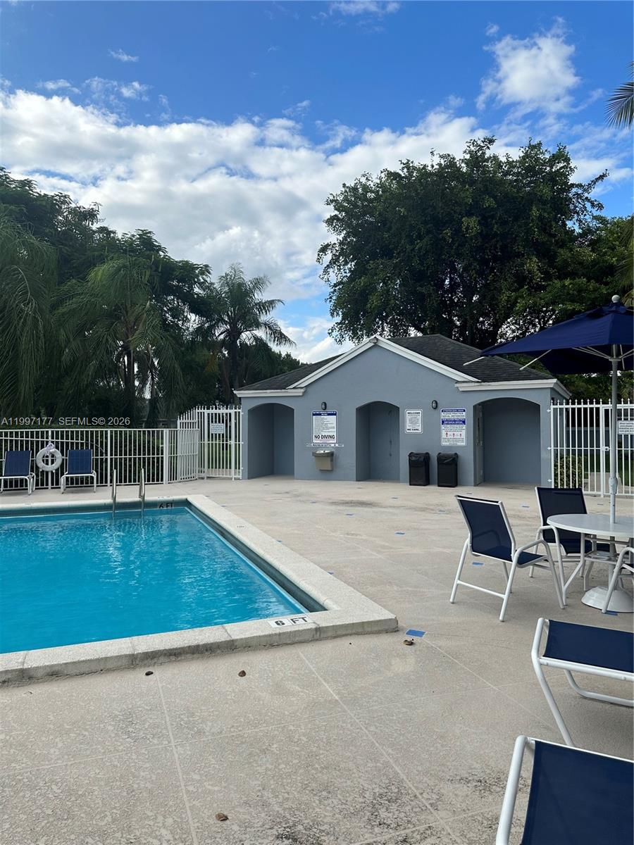 9724 Southwest 142nd Place Miami, FL 33186 - Photo 34 of 36 a view of a patio with table and chairs with wooden floor and fence