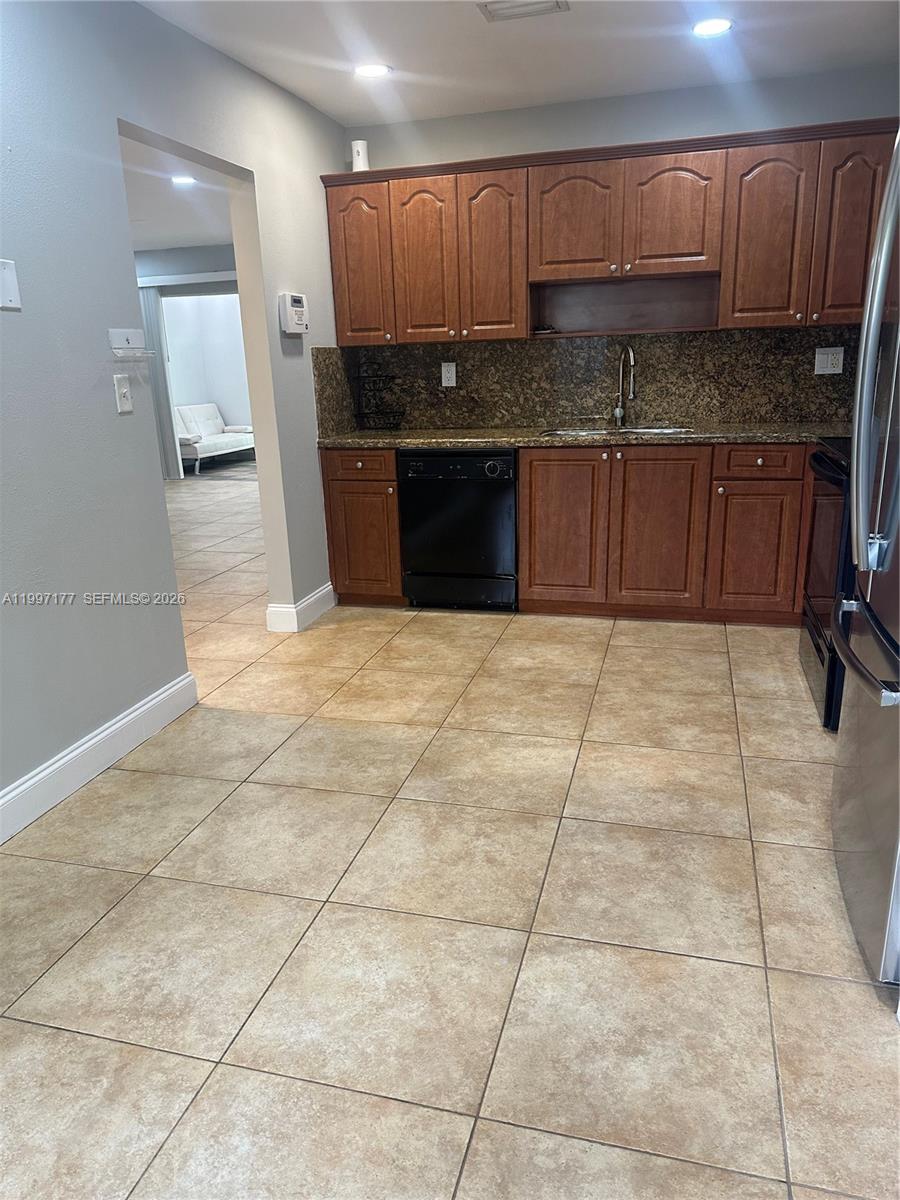 9724 Southwest 142nd Place Miami, FL 33186 - Photo 4 of 36 a large kitchen with granite countertop a stove a sink and a microwave