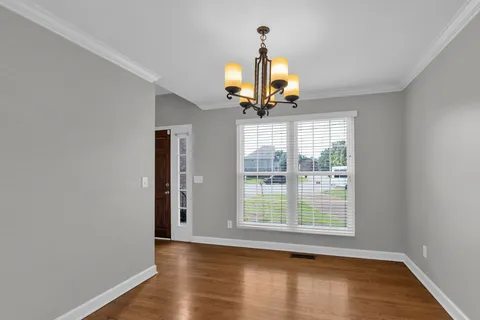 a view of a livingroom with a window and wooden floor