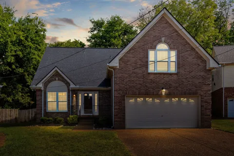 a front view of a house with a yard and trees