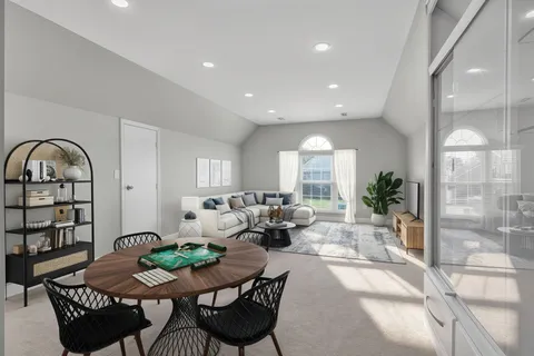 a living room with furniture a large window and a potted plant
