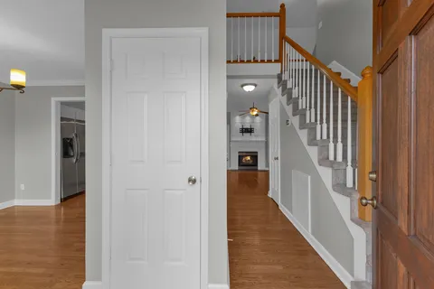 a view of a hallway with wooden floor and staircase