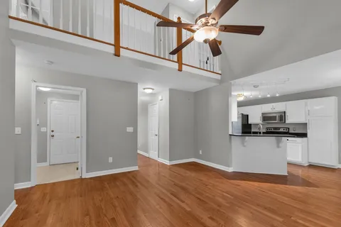 a view of a kitchen with a sink hardwood floor and a ceiling fan