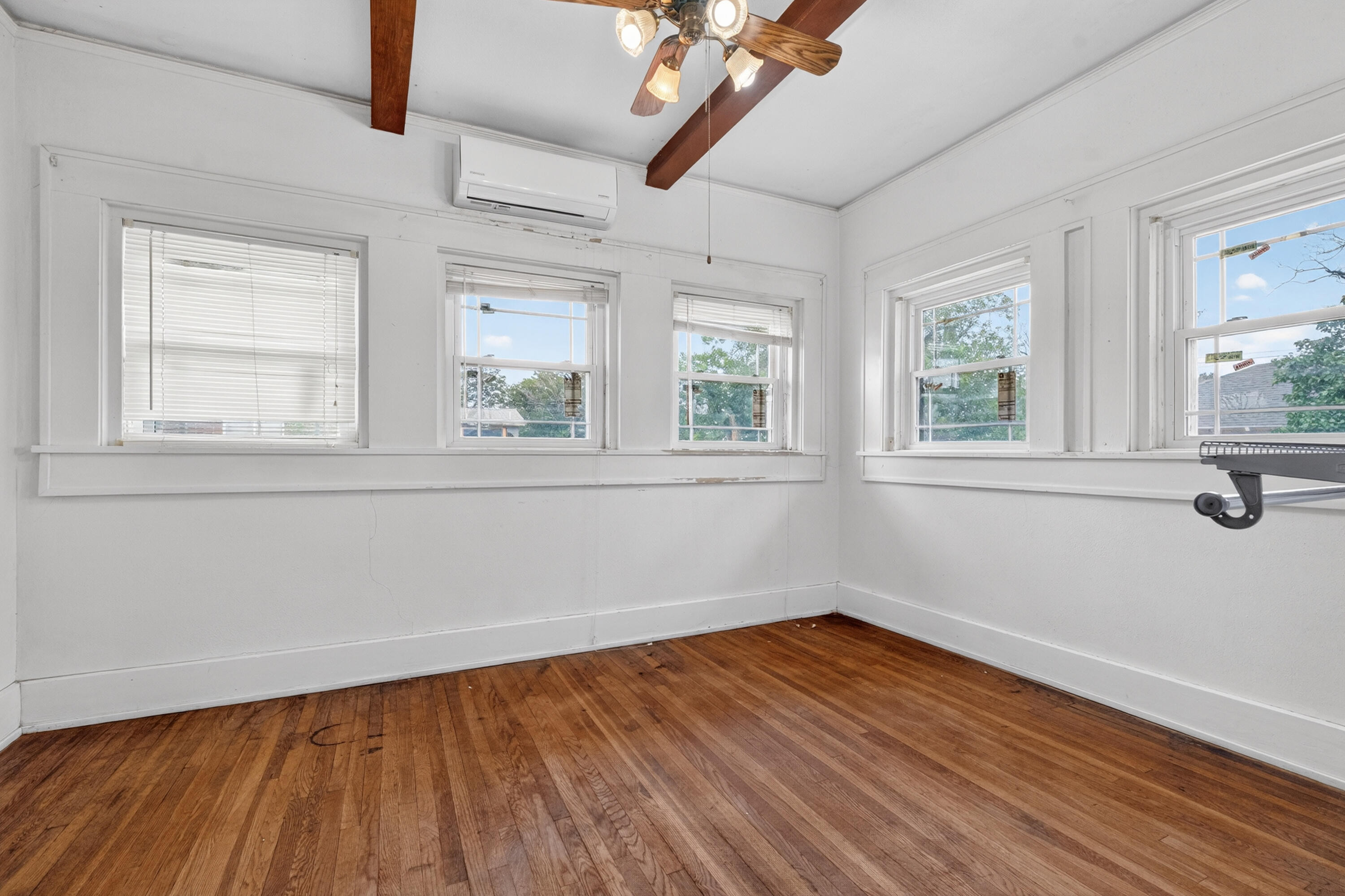 500 West Garza Street Slaton, TX 79364 - Photo 13 of 24 an empty room with wooden floor and windows