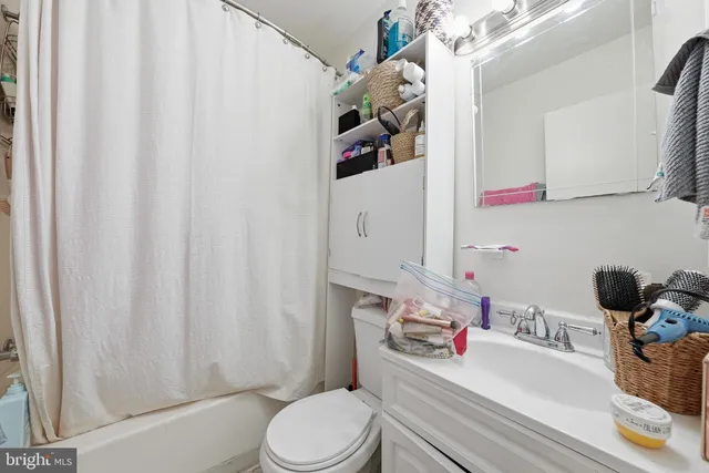 a bathroom with a sink a toilet and shower curtain