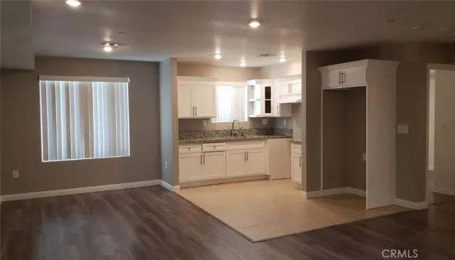 a kitchen with a refrigerator and white cabinets