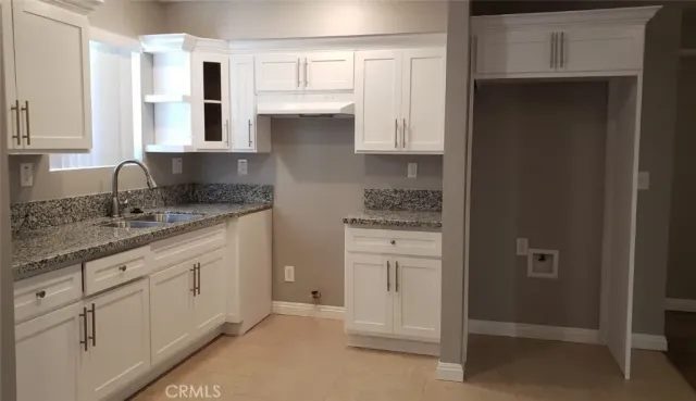a spacious bathroom with a granite countertop sink and a mirror