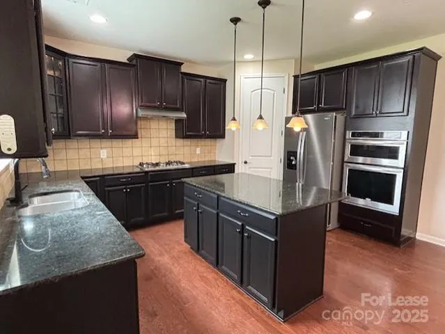 a kitchen with wooden cabinets and stainless steel appliances