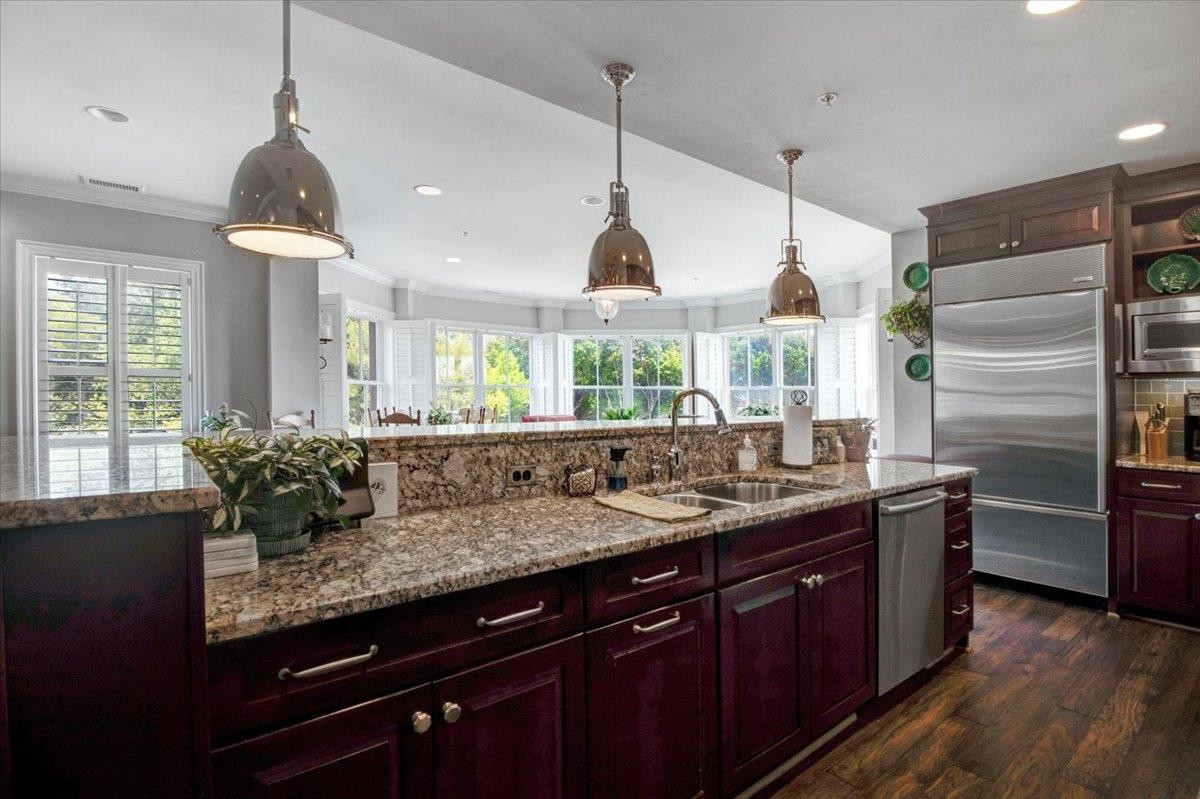 710 Independence Place, Unit 406 Raleigh, NC 27603 - Photo 15 of 50 a kitchen with granite countertop a sink and refrigerator