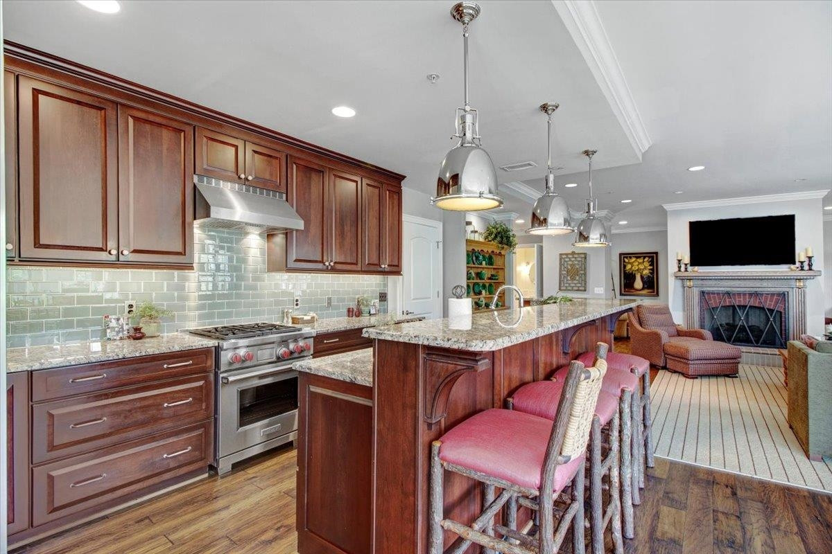 710 Independence Place, Unit 406 Raleigh, NC 27603 - Photo 21 of 50 a large kitchen with stainless steel appliances kitchen island granite countertop a sink dishwasher a dining table and chairs with wooden floor