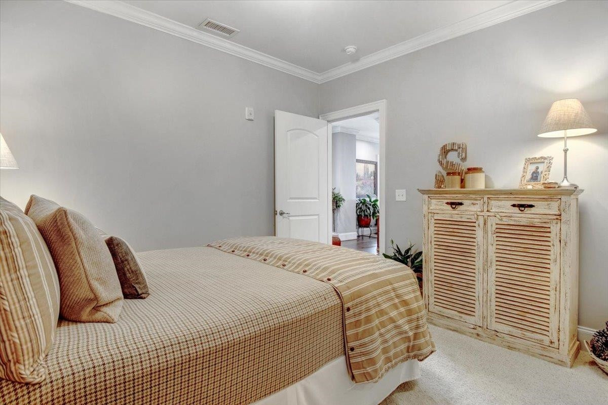 710 Independence Place, Unit 406 Raleigh, NC 27603 - Photo 45 of 50 a bedroom with a bed and dresser with mirror