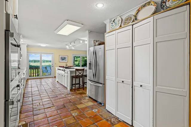 a kitchen with stainless steel appliances granite countertop a refrigerator and a stove top oven