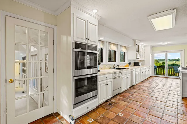 a large white kitchen with cabinets and stainless steel appliances