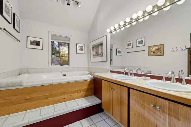 a bathroom with a tub sink and mirror