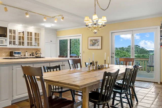 a view of a dining room with furniture a chandelier and wooden floor