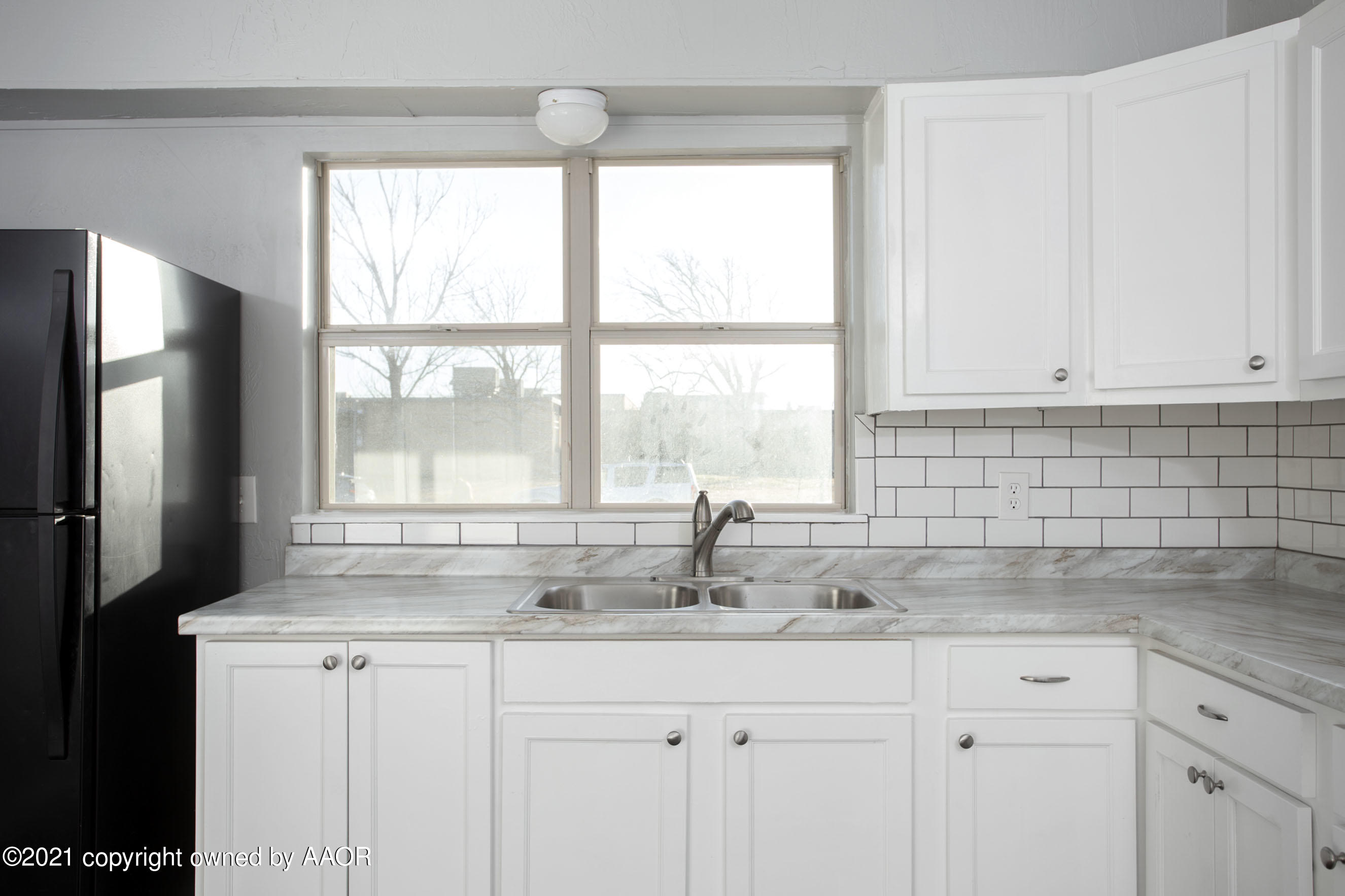 4622 South Rusk Street Amarillo, TX 79110 - Photo 7 of 22 a kitchen with granite countertop white cabinets and a window