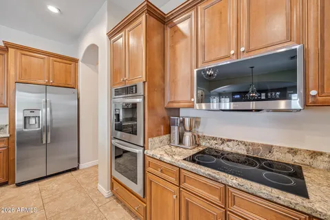 a kitchen with stainless steel appliances granite countertop sink stove and refrigerator