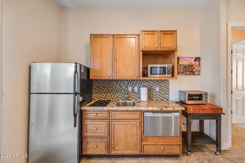 a large bed sitting in a bedroom next to a window and a chandelier