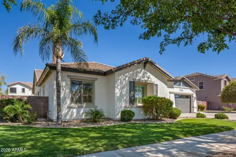 a front view of a house with a yard and potted plants