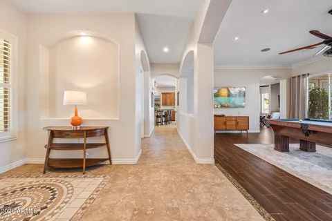 a view of a hallway with wooden floor and a bathroom