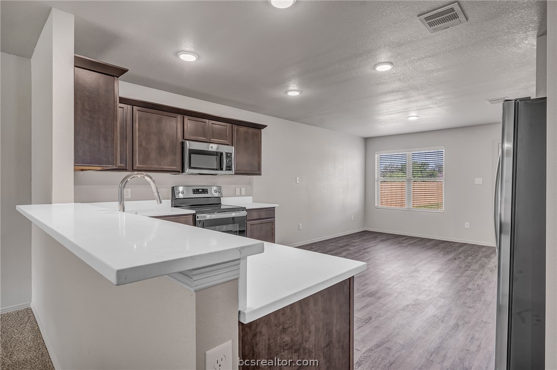 1635 Lucky Street Bryan, TX 77803 - Photo 4 of 11 a kitchen with a sink a microwave and cabinets