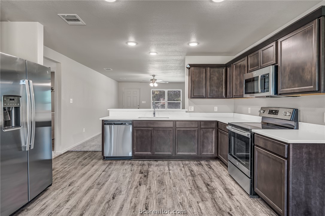 1635 Lucky Street Bryan, TX 77803 - Photo 6 of 11 a kitchen with stainless steel appliances granite countertop a sink and wooden cabinets