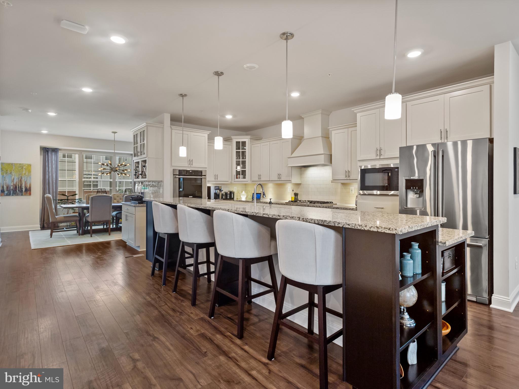 2762 Lady Slipper Road Gambrills, MD 21054 - Photo 4 of 43 a kitchen with stainless steel appliances kitchen island granite countertop a table chairs and a refrigerator