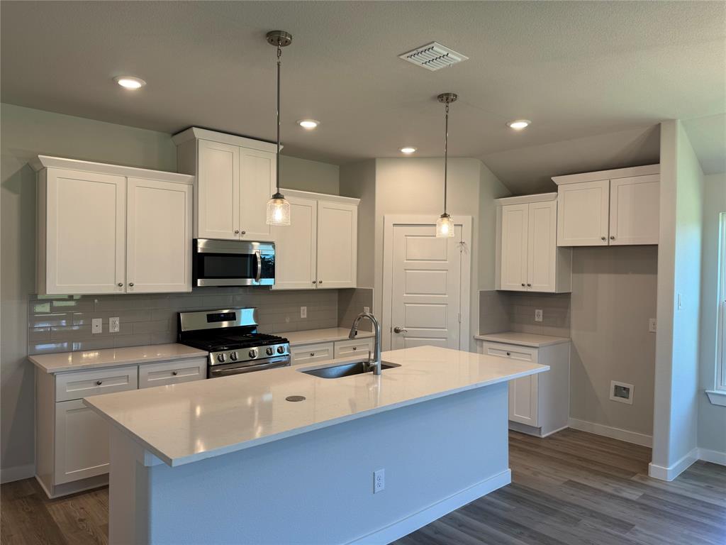605 Finlee Way Tioga, TX 76271 - Photo 13 of 22 a kitchen with kitchen island a sink stainless steel appliances and white cabinets