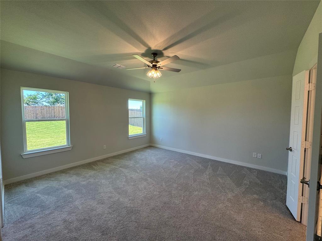 605 Finlee Way Tioga, TX 76271 - Photo 17 of 22 an empty room with windows and fan