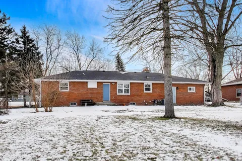 a front view of house with yard covered in snow