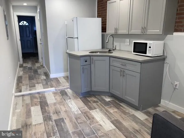 a kitchen with white cabinets and refrigerator