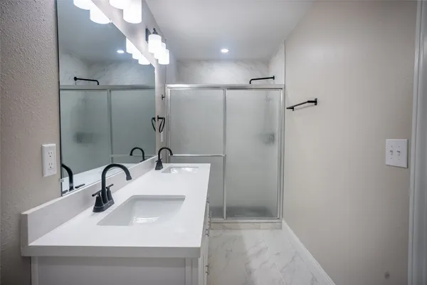 a bathroom with a sink a mirror and shower