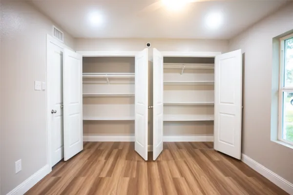 a view of walk in closet with empty racks